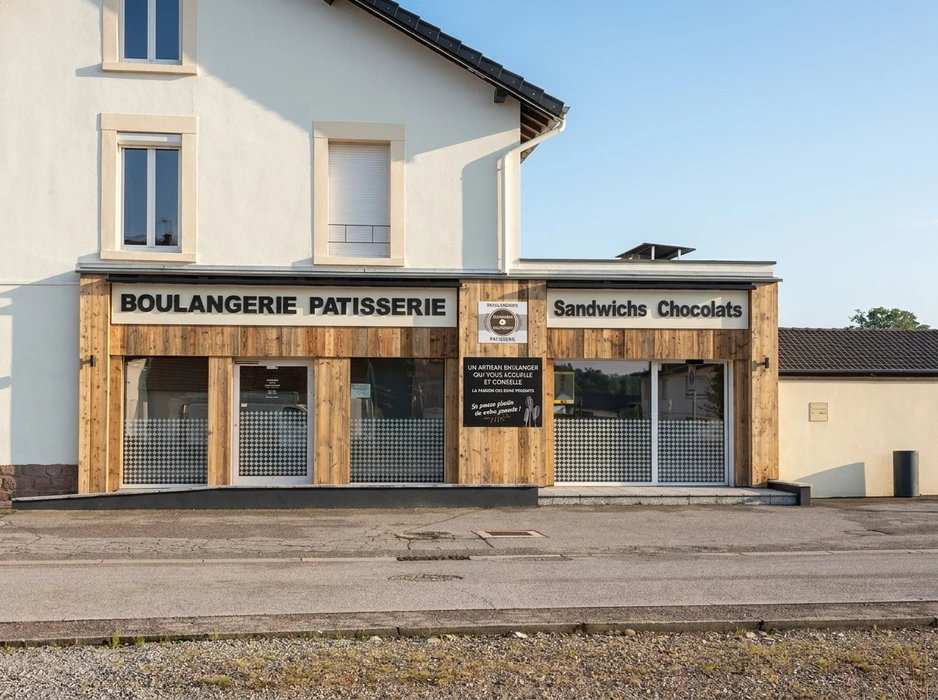 Un chef de chantier ou coordinateur professionnel en tenue de travail (gilet haute visibilité, casque de sécurité) debout dans un grand chantier de rénovation, supervisant et communiquant avec plusieurs artisans différents travaillant simultanément : un électricien posant du câblage, un plombier installant des tuyauteries, un installateur de climatisation réversible travaillant sur l'unité intérieure, et une unité de VMC en arrière-plan. Le coordinateur apparaît comme le point central, confident et en contrôle du projet global, incarnant l'interlocuteur unique capable de gérer l'ensemble des disciplines.