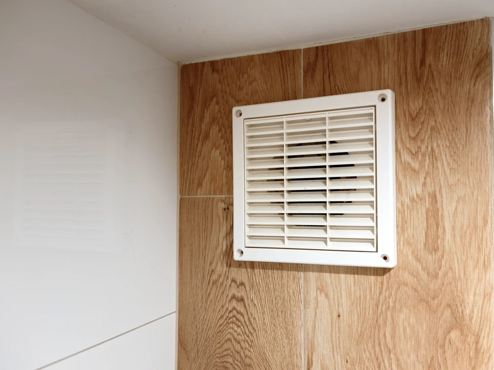 Ouvrier installant un plafond suspendu en plaques de plâtre dans un intérieur résidentiel