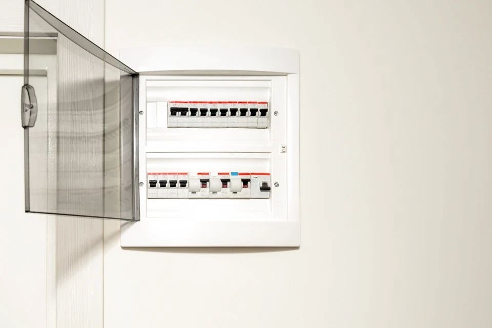 Électricien en équipement de protection individuelle travaillant sur installation électrique intérieure